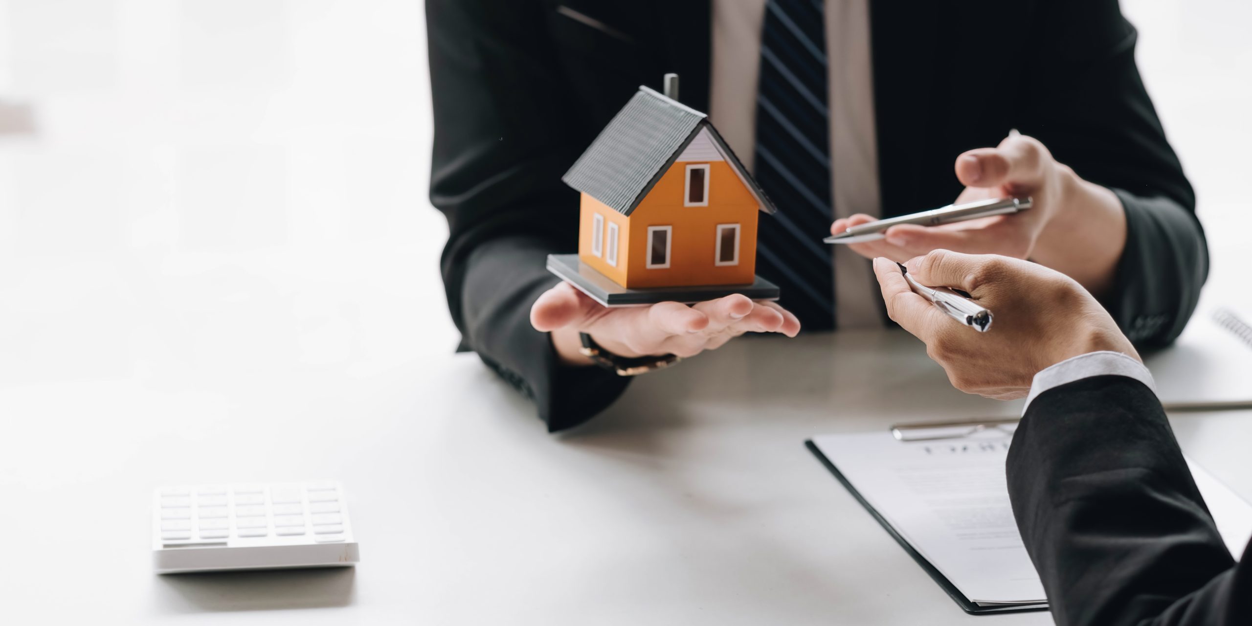 Real estate broker agent presenting and consult to customer to decision making sign insurance form agreement, home model, concerning mortgage loan offer for and house insurance.